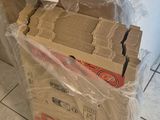 une boîte de papier toilette posée par terre à côté d'un rouleau de papier toilette
