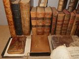 many old books sitting on a table with a book case