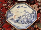three blue and white plates on a red rug with oriental designs