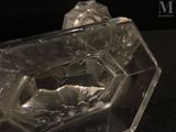 a glass ashtray with a cigarette in it on a black surface