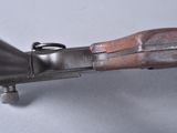 an old gun with a wooden handle on a white surface