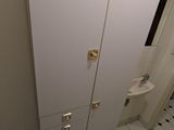une salle de bains équipée de toilettes, d'un lavabo et de placards
