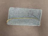 a small gray bag with a yellow zipper on it