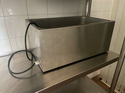 un grille-pain argenté posé sur une étagère en métal dans une cuisine