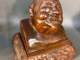 a wooden statue of a man with a smile on his face