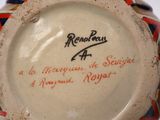 a ceramic vase with writing on it on a table