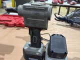 a drill and a battery on a table in a room