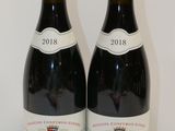 deux bouteilles de vin posées sur une table l'une à côté de l'autre