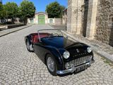 une voiture noire et rouge garée dans une rue pavée