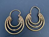 une paire de boucles d'oreilles en or sur une surface noire
