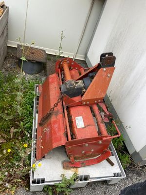 une tondeuse à gazon rouge posée par terre