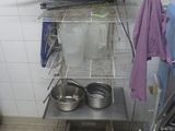 a kitchen with a stove and a rack with pots and pans on it
