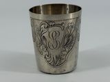 une tasse en argent antique avec un motif floral sur le bord