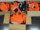 des cartons contenant des vêtements orange et noirs posés sur un sol noir