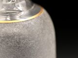 a silver vase with a gold rim sitting on a table