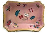 une assiette rose décorée d'un oiseau et de fleurs