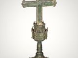 an old bronze cross on a pedestal with a white background