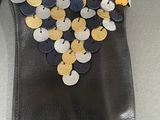 a black purse with gold and silver coins on it