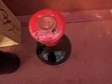 une bougie rouge posée sur le sol à côté d'une boîte