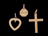 trois types différents de pendentifs en forme de croix et de cœur sur fond noir