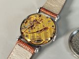 a watch that is sitting on a table next to a pocket watch