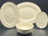 three white plates and a bowl are sitting on a table