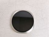 a round black button on a white surface