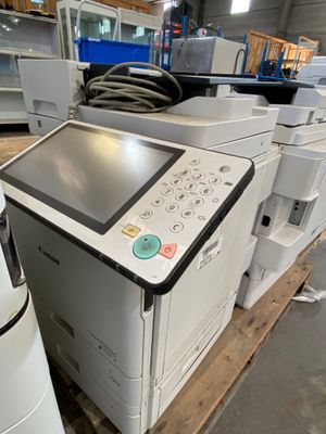de nombreuses imprimantes, empilées sur une palette dans un entrepôt