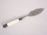 a silver spoon with a white handle on a white surface