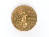 une pièce d'or ornée d'un oiseau sur une surface blanche