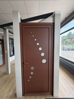 une porte marron percée de trous dans une pièce