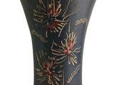 a black vase with red flowers painted on it
