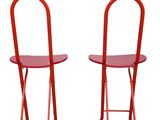 pair of red metal folding chairs against a white background