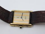 a watch that has a brown strap around it