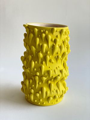 deux vases jaunes posés côte à côte sur une surface blanche