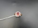 un gros plan d'une bague avec un diamant rose monté sur un fil