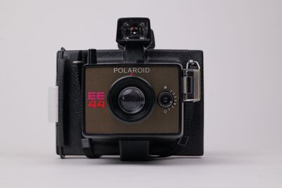 un vieil appareil photo Polaroid posé sur une table