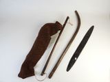 a knife, a cane, and a cloth bag on a table