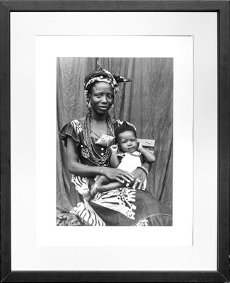 an old black and white photo of a woman holding a baby