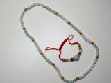 un collier de perles orné d'un ruban rouge