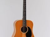 une guitare acoustique accrochée à un mur sur fond blanc