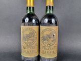 two bottles of wine sitting next to each other on a table