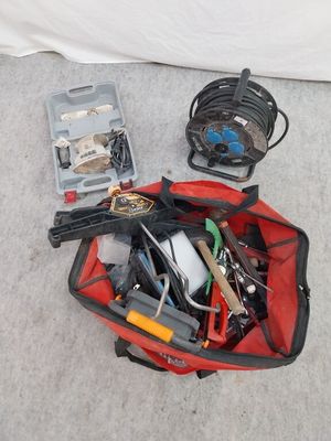 un sac rouge contenant des outils, posé par terre