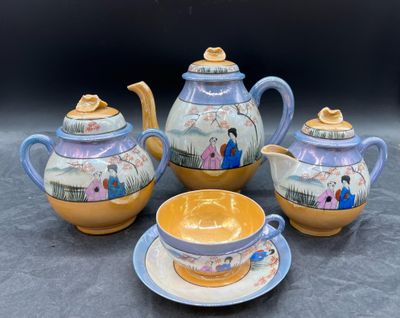 trois théières et une tasse posées sur une table
