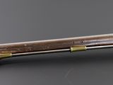 a close up of a rifle with a wooden handle on a table