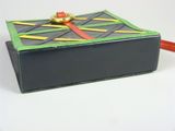 a black box with a red handle on a white table