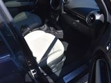 the interior of a car with the door open and the driver ' s seat down