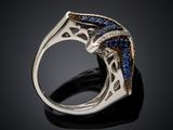 a close up of a ring with blue sapphires on a black surface