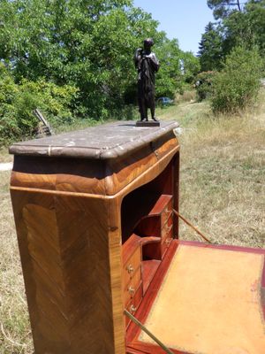 un petit bureau en bois sur lequel se trouve une statue