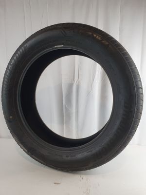 a close up of a tire on a white surface with a curtain behind it